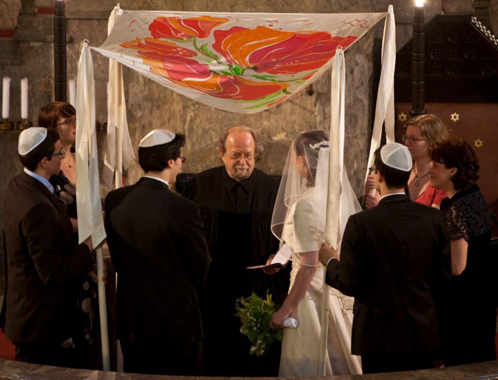 EIn Brautpaar vor einem Rabbiner unter einer Chuppa in der Augsburger Synagoge.