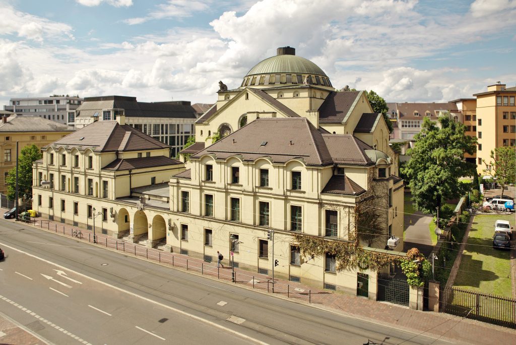View of a big yellowish building with a cupola, the Augsburg synagogue.