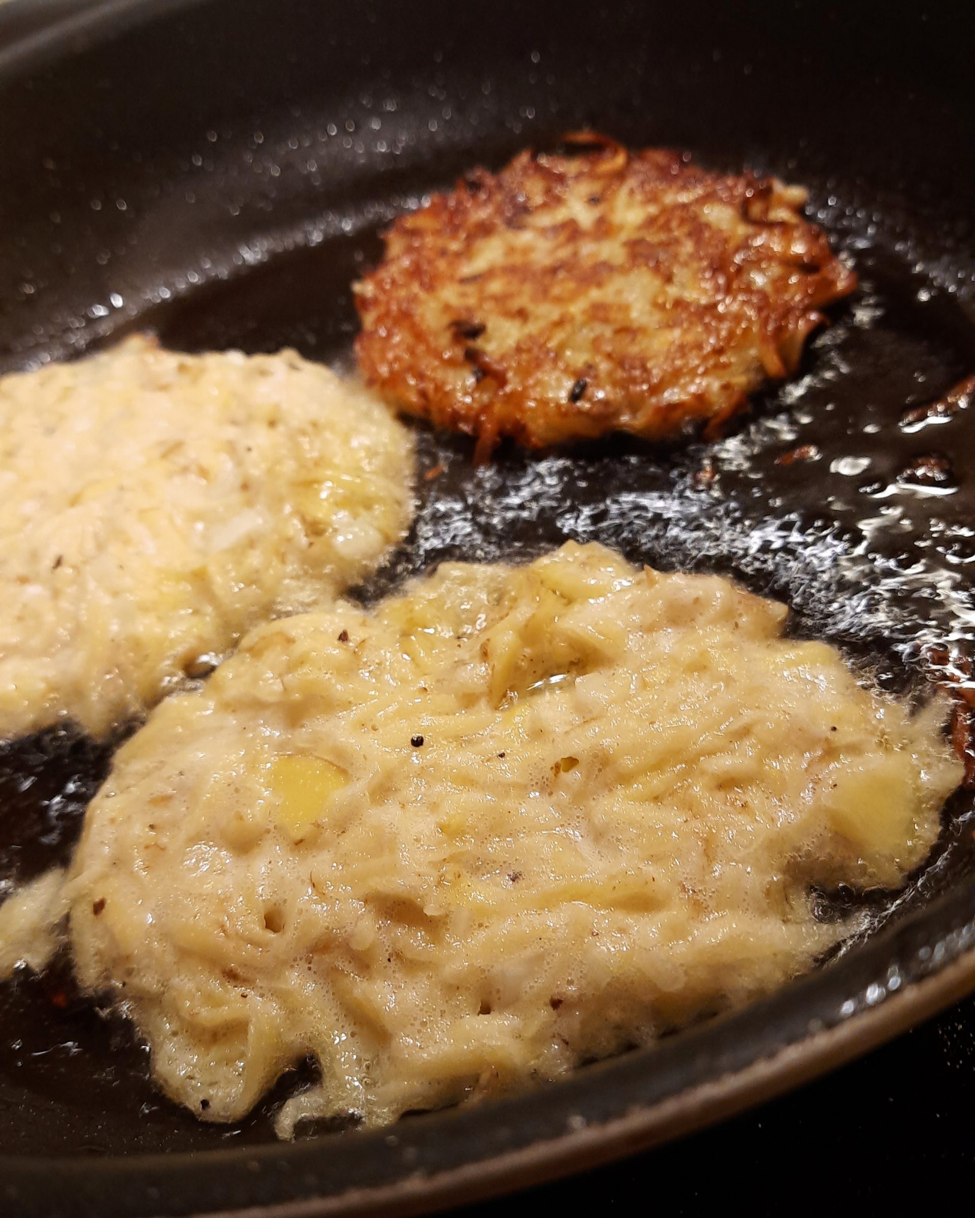 Foto einer Pfanne mit drei Kartoffelpuffern.
