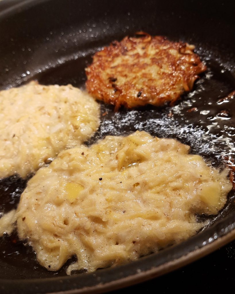 Foto einer Pfanne mit drei Kartoffelpuffern.
