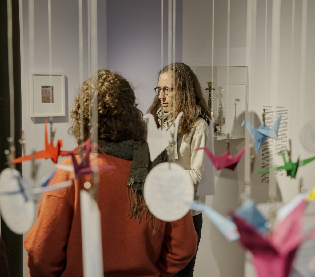 Eine Gruppe Menschen in einem Raum mit Vitrinen in weiß und blau