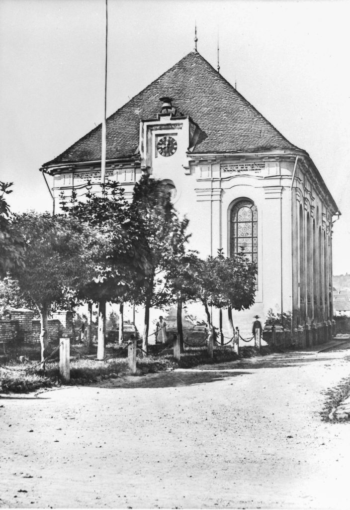 schwarz-weiß Bild eines Gebäudes mit hohen Fenstern, davor Bäume